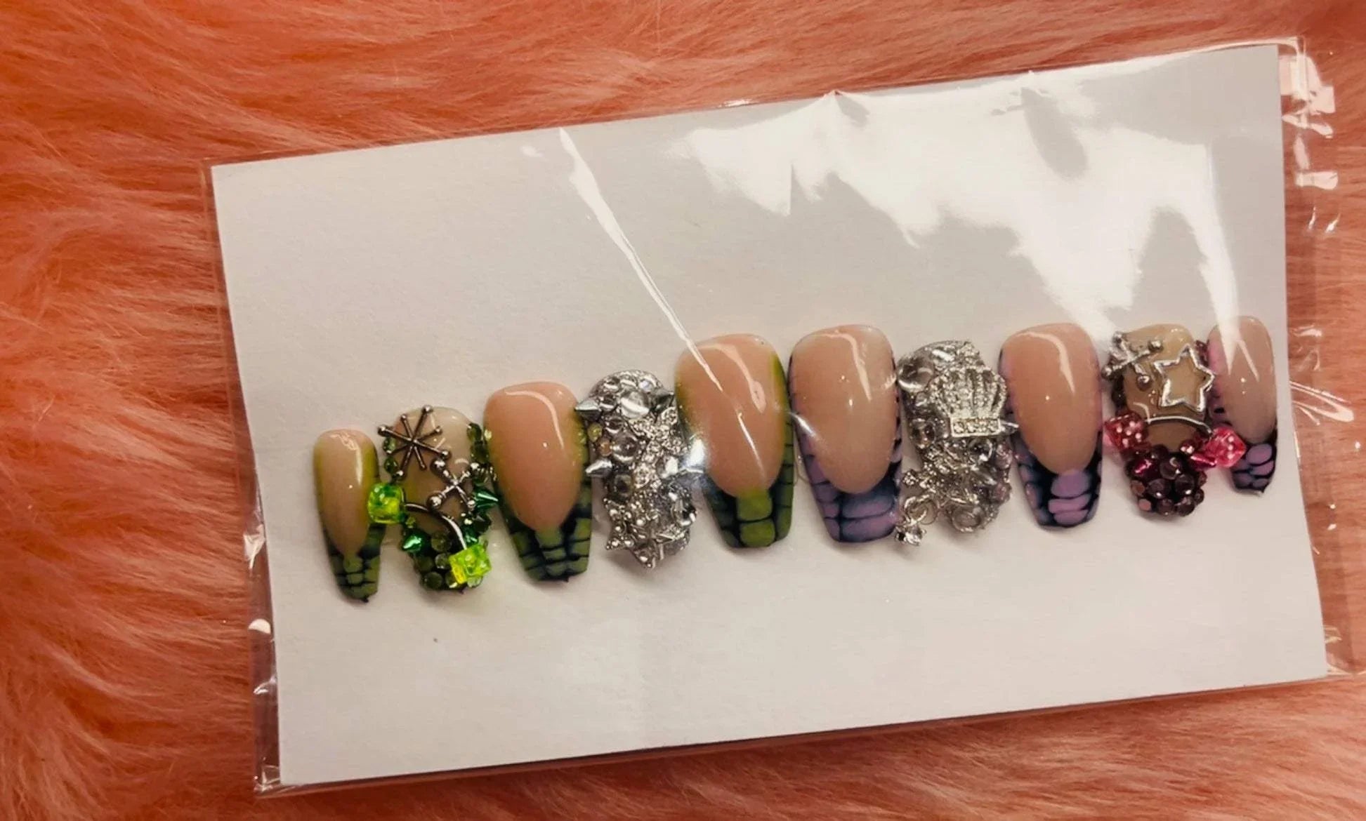 Strawberry Keywee press-on nails with silver charms in pink, black, and green on a white card background