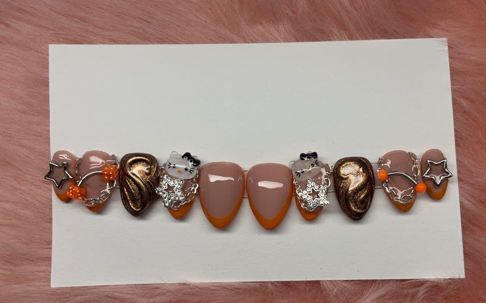 Set of orange kitty cat-themed decorative press-on nails with star and bead embellishments